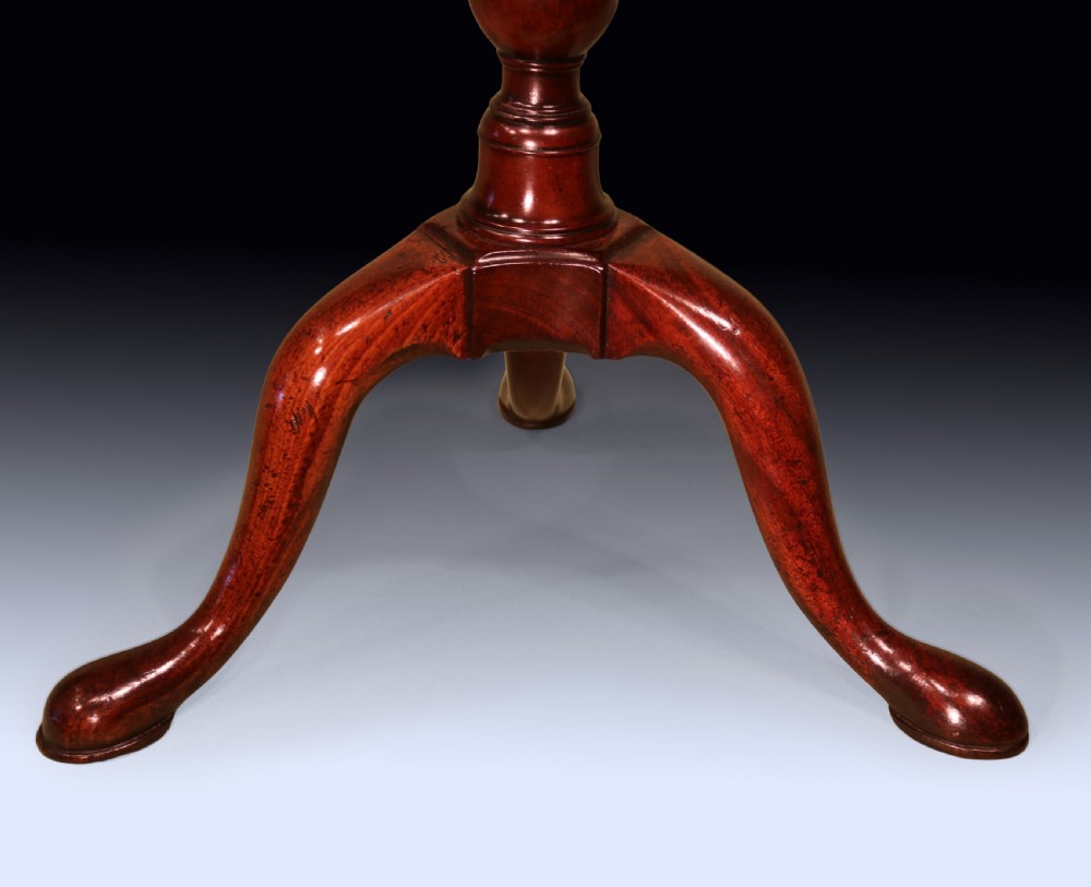 An 18th-century George II mahogany kettle stand with a circular dished top, a central turned baluster stem, and three cabriole legs. View III