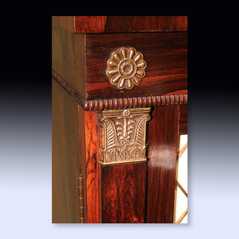 A matching pair of dark rosewood Regency side cabinets featuring brass inlay, mirrored top tiers with brass galleries, and pleated fabric behind brass grilles on the doors. View VIII