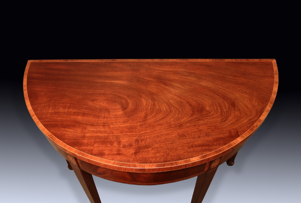 A pair of late 18th-century semi-circular mahogany card tables featuring inlaid rosettes and square tapered legs. View V