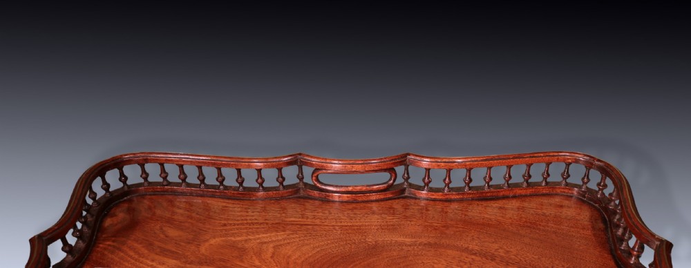 An antique Chippendale style mahogany tripod wine table featuring a rectangular tray top with a spindle gallery and turned pedestal base. View IV