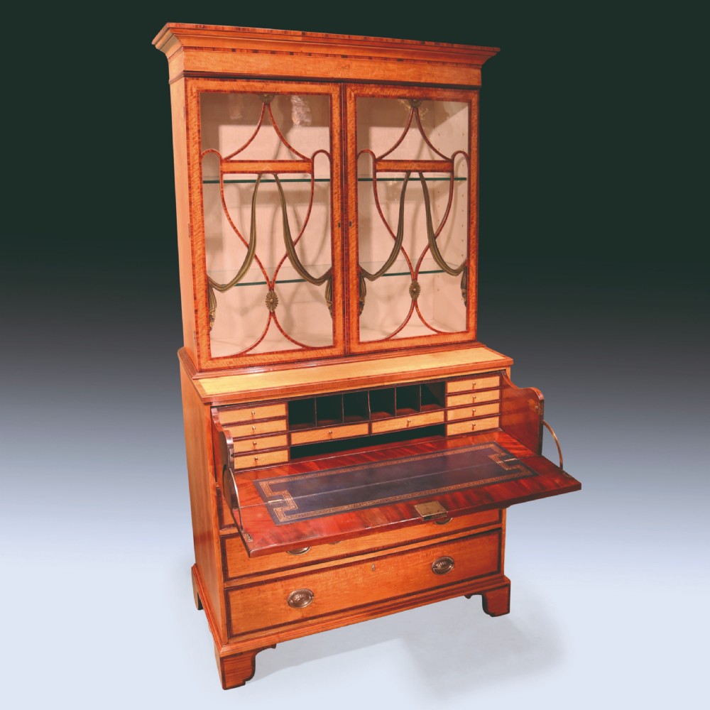 A Sheraton period satinwood secretaire bookcase featuring astagal glazed doors on the upper display cabinet over a chest of drawers. View III