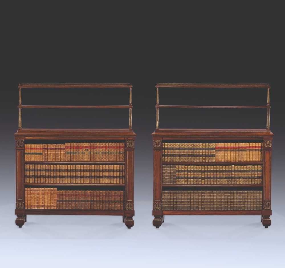 A matching pair of 19th-century Regency dark rosewood open bookcases featuring upper brass tiered shelves and corner mounts.