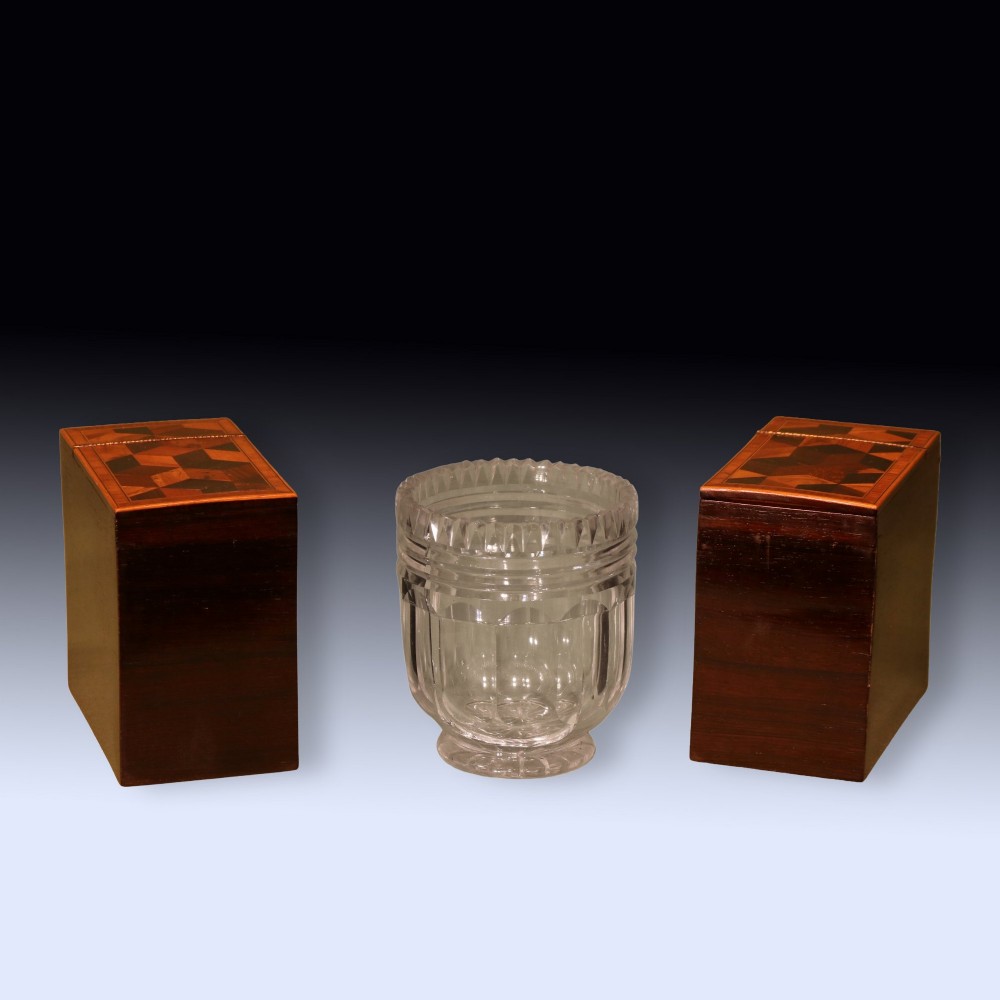 A Regency period wooden tea caddy featuring geometric parquetry inlay, a hinged lid, and small brass feet. View V