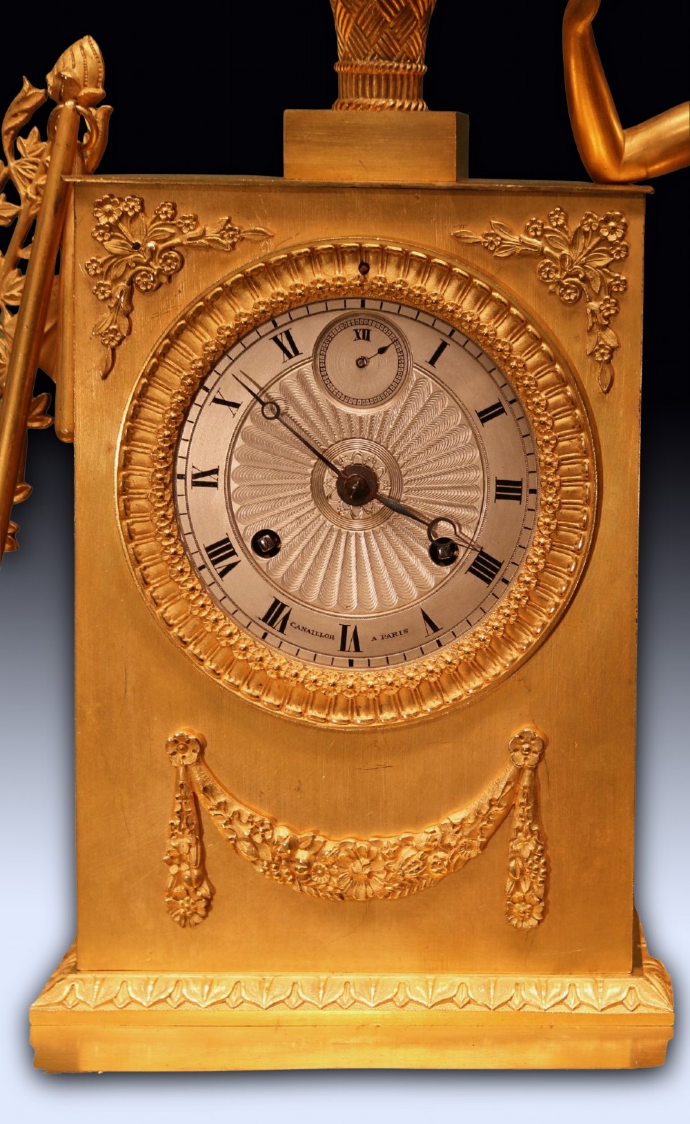 An early 19th-century French gilt bronze ormolu clock featuring a classical female figure standing beside a rectangular housing topped with a fruit basket. View II