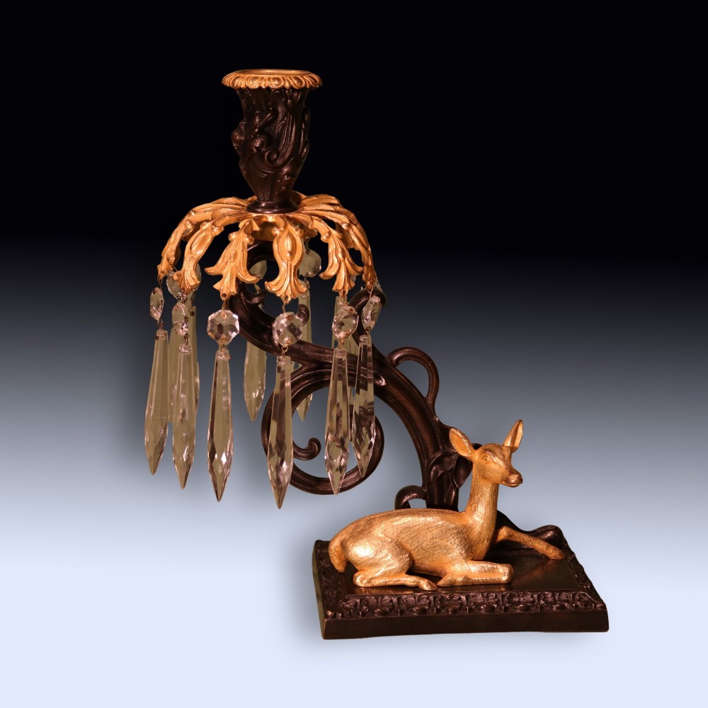 A pair of 19th-century dark bronze candlesticks featuring gilt ormolu figures of a stag and a doe sitting beneath glass prism lustres. View III