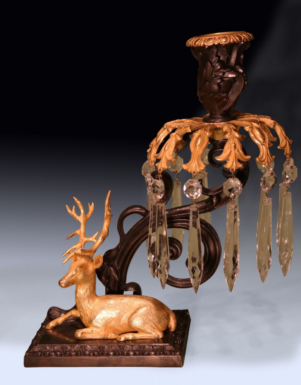 A pair of 19th-century dark bronze candlesticks featuring gilt ormolu figures of a stag and a doe sitting beneath glass prism lustres. View IV