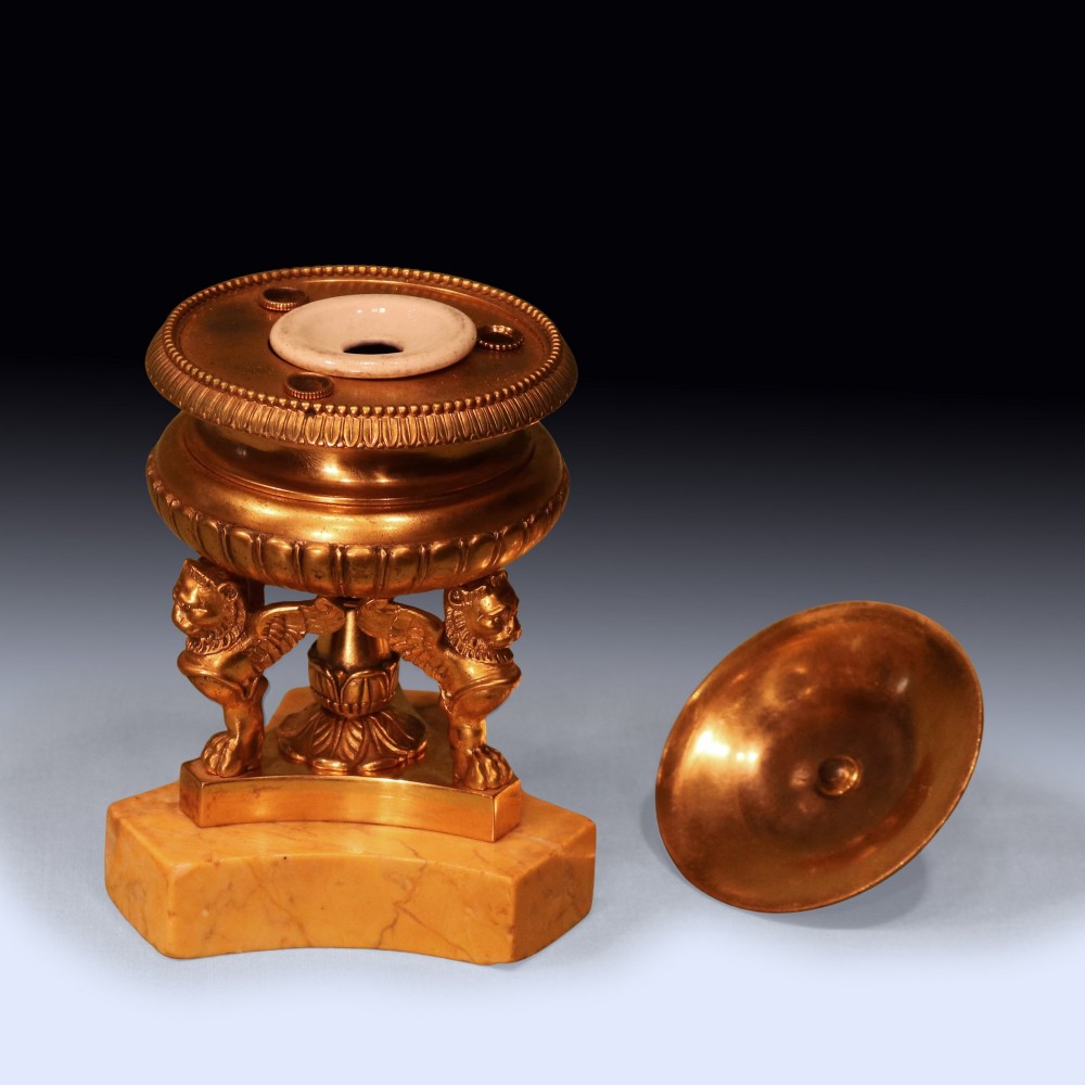 An early 19th-century urn-shaped ormolu inkwell supported by three winged lion monopodia legs on a shaped yellow Sienna marble base. View II