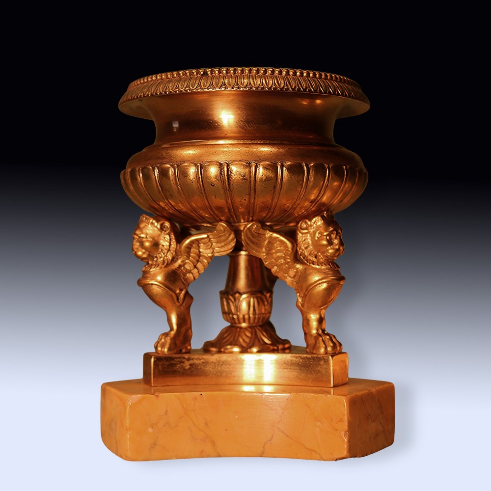 An early 19th-century urn-shaped ormolu inkwell supported by three winged lion monopodia legs on a shaped yellow Sienna marble base. View III