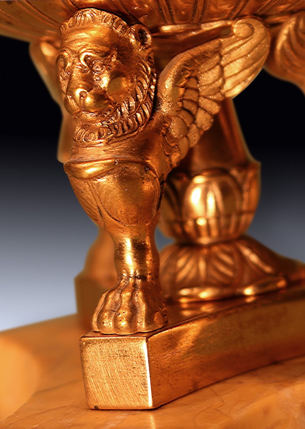 An early 19th-century urn-shaped ormolu inkwell supported by three winged lion monopodia legs on a shaped yellow Sienna marble base. View IV