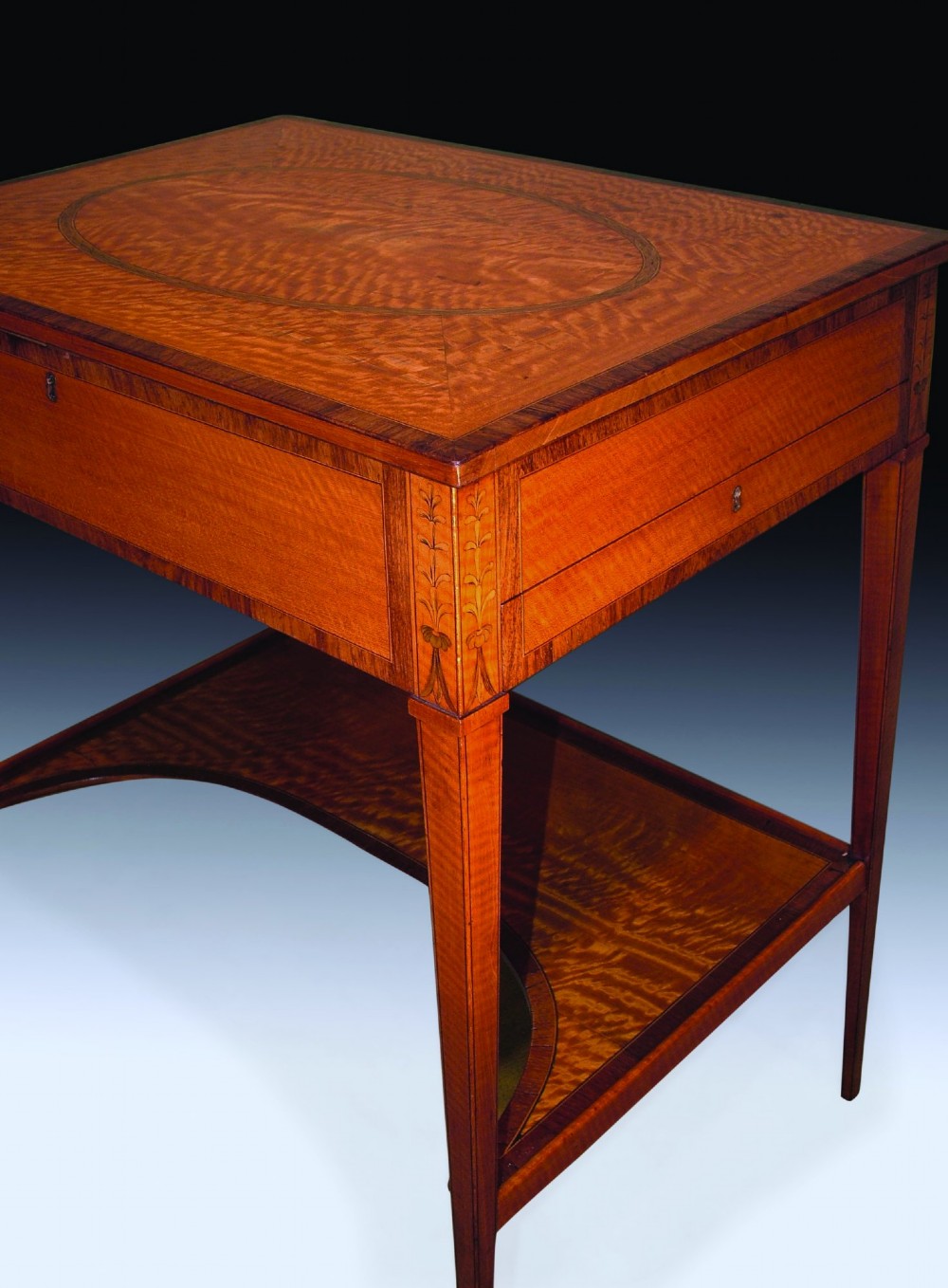 An antique Sheraton period satinwood occasional table featuring a rectangular top with an oval central inlay, a single drawer, tapered square legs, and a concave undertier. View IV