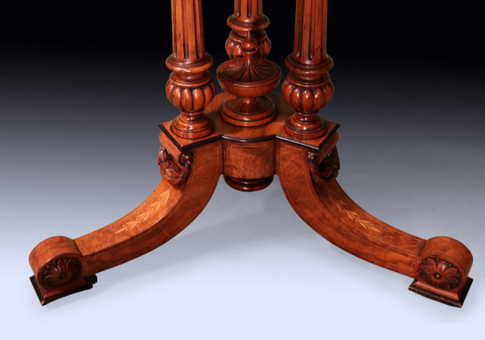 A circular mid 19th-century burr walnut centre table featuring central marquetry inlay and a carved pedestal base with splayed legs. View V