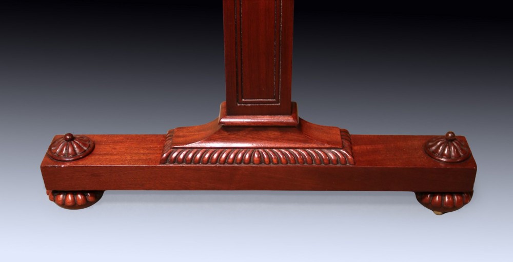 An antique Regency period mahogany writing table featuring an inset leather top, a brass gallery rail, and drawers set on twin end supports. View VI