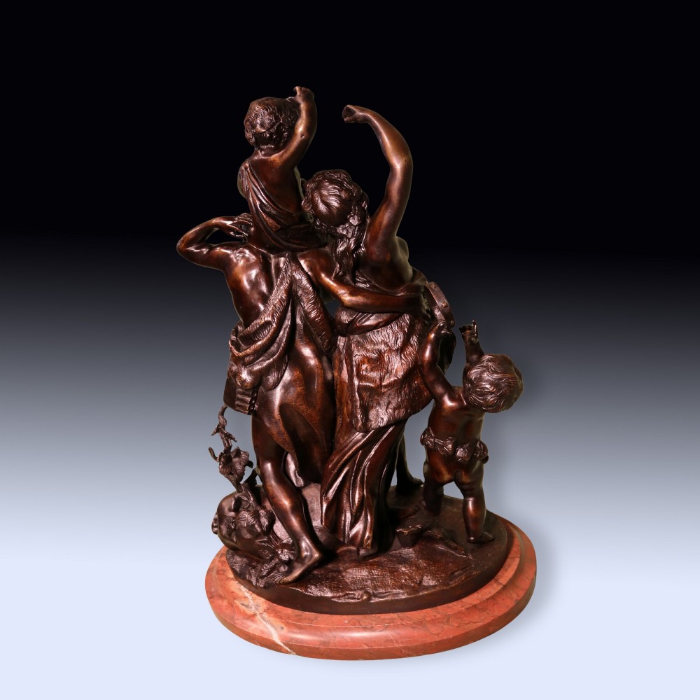 A 19th-century patinated bronze sculpture depicting Bacchanalian classical figures and cherubs mounted on a circular red marble base. View II