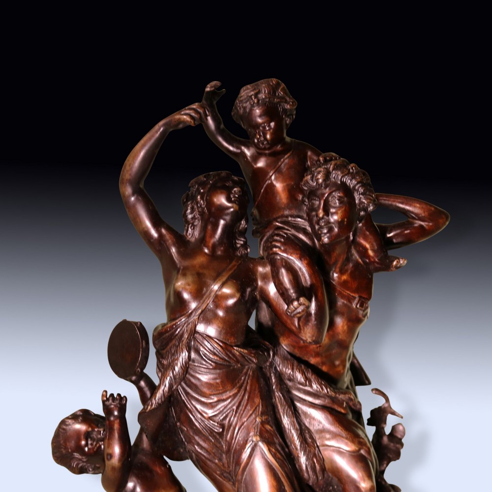 A 19th-century patinated bronze sculpture depicting Bacchanalian classical figures and cherubs mounted on a circular red marble base. View IV