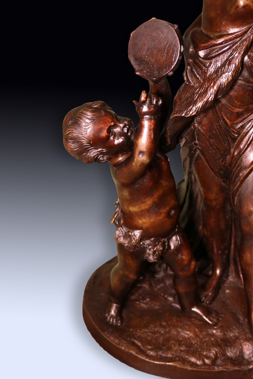 A 19th-century patinated bronze sculpture depicting Bacchanalian classical figures and cherubs mounted on a circular red marble base. View VI