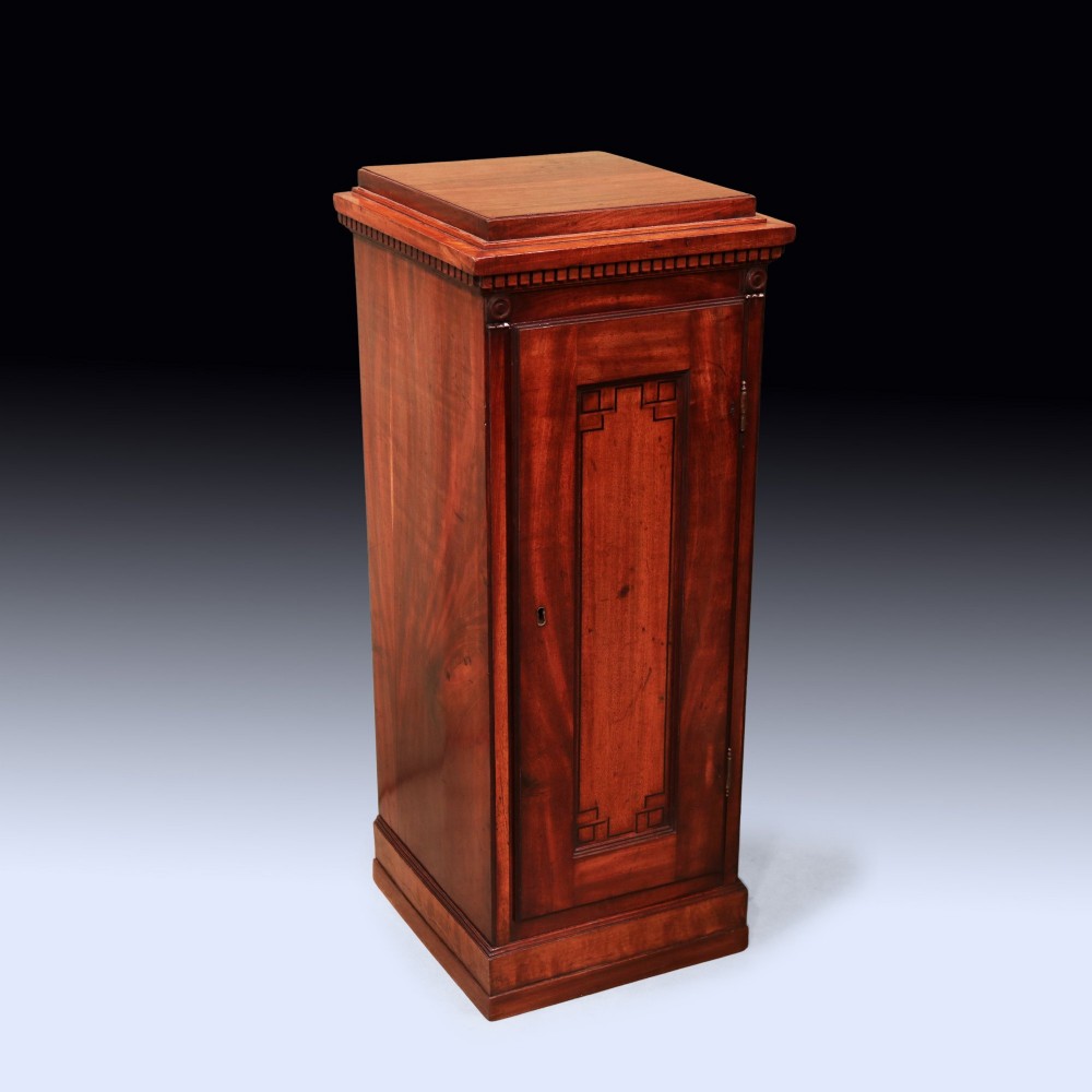 A pair of matching George III period mahogany pedestal cupboards featuring flame mahogany panel doors and plinth bases. View III