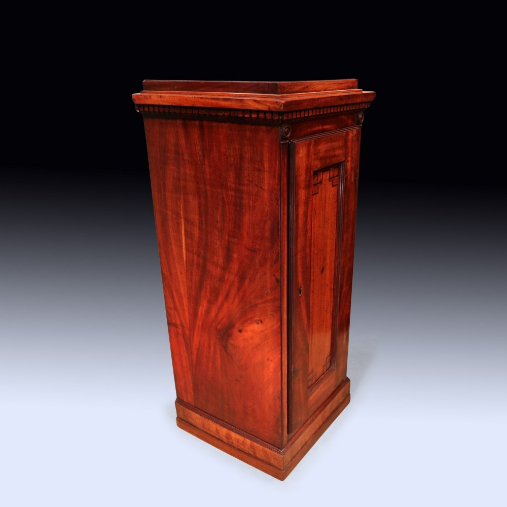 A pair of matching George III period mahogany pedestal cupboards featuring flame mahogany panel doors and plinth bases. View VI
