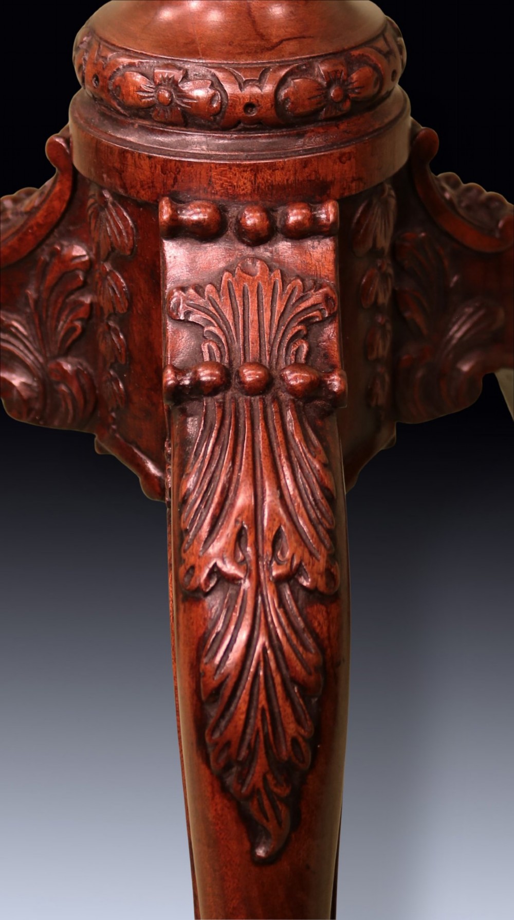 A dark mahogany tripod kettle stand featuring an octagonal tray top, fluted column stem, and carved acanthus leaf cabriole legs with scroll feet. View V