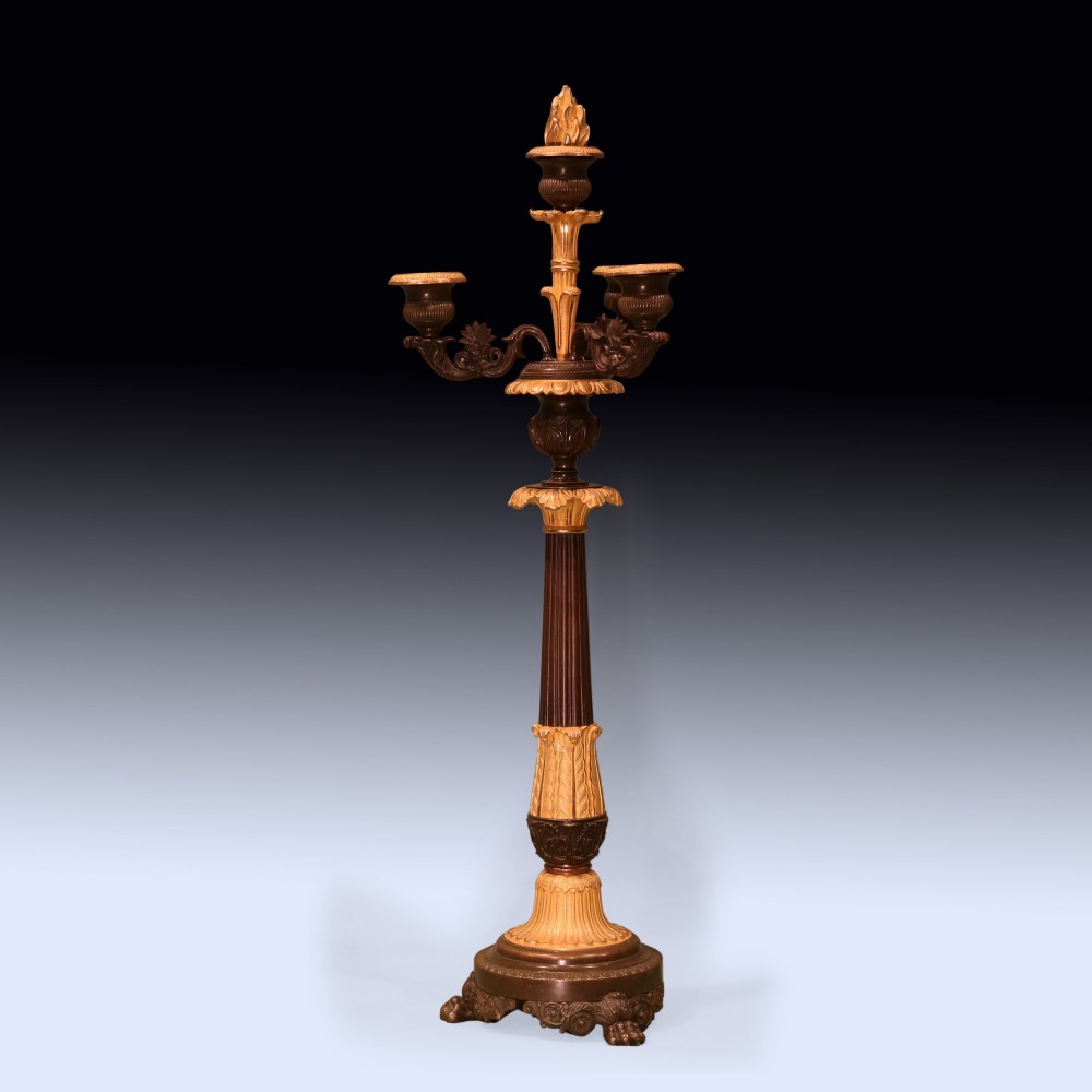 A pair of tall Regency period bronze and ormolu four-light candelabra featuring fluted shafts, gilt leaf detailing, and paw feet. View II