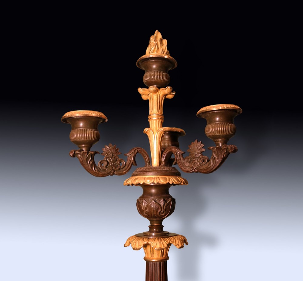 A pair of tall Regency period bronze and ormolu four-light candelabra featuring fluted shafts, gilt leaf detailing, and paw feet. View III