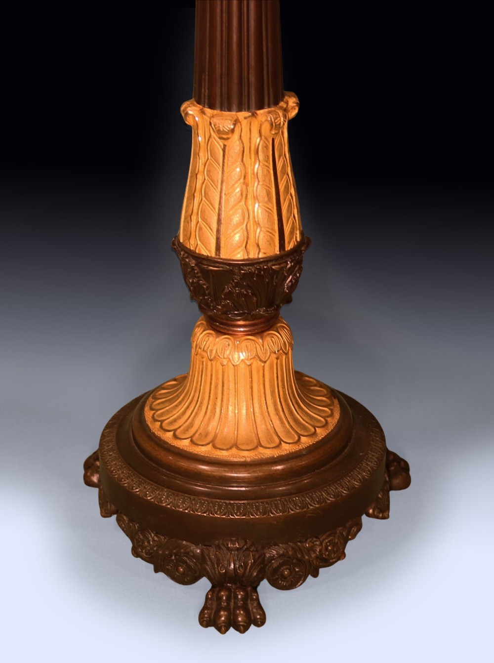 A pair of tall Regency period bronze and ormolu four-light candelabra featuring fluted shafts, gilt leaf detailing, and paw feet. View IV