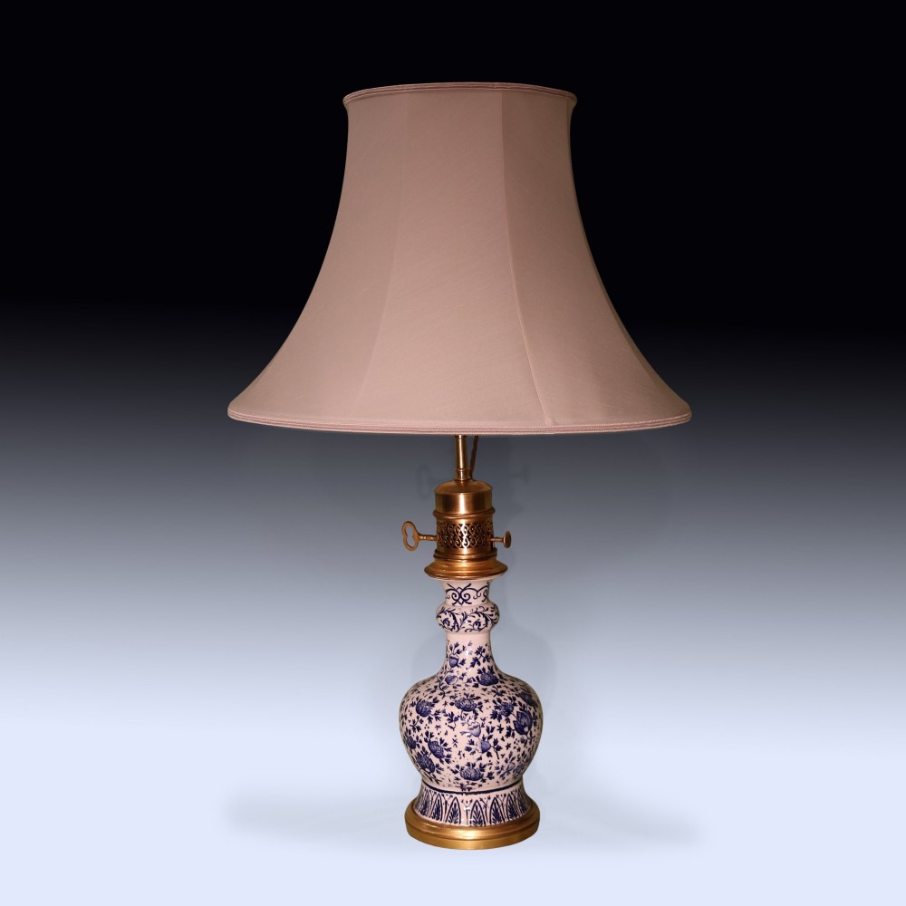 A pair of mid 19th century Chinese blue and white porcelain oil lamps with brass mounts and cream fabric shades. View II