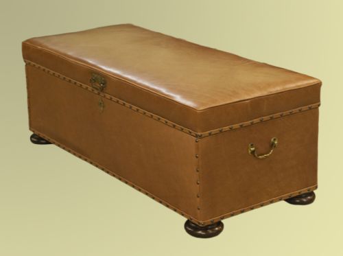 A Victorian Tan Leather Upholstered Ottoman with Bun Feet