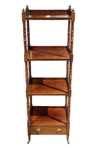 fig 1. An antique Victorian four-tier mahogany whatnot featuring turned spindle supports, top finials, a lower drawer with brass handles, and brass castors.