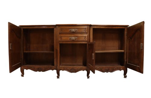 fig 1. A French Louis XV style warm brown oak sideboard featuring three carved panel doors, two central drawers, brass hardware, and cabriole feet.