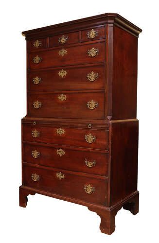 fig 1. A tall George III mahogany chest on chest featuring two stacked sections with multiple drawers, ornate pierced brass handles, and standing on bracket feet.