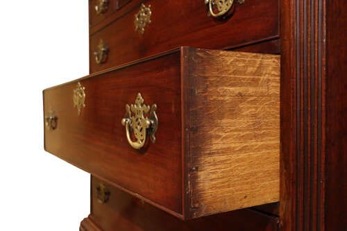 fig 2. A tall George III mahogany chest on chest featuring two stacked sections with multiple drawers, ornate pierced brass handles, and standing on bracket feet.