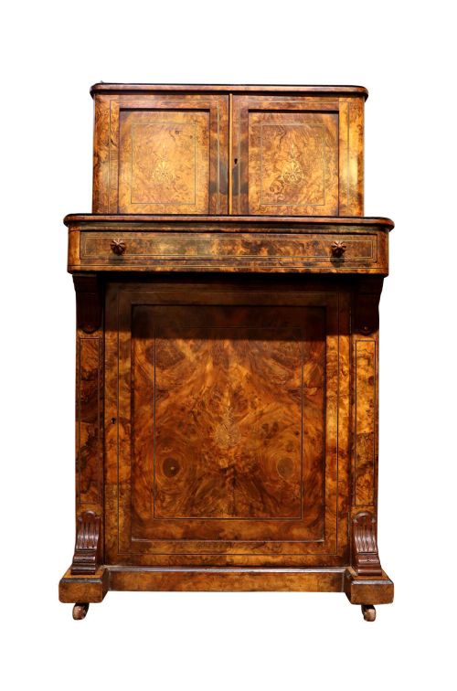 A Victorian burr walnut bureau de dame featuring intricate brass inlay, a top cabinet with twin doors, a full-width drawer, and a lower cupboard set on castors.