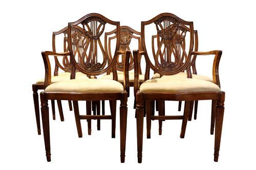 fig 1. A set of eight mahogany dining chairs with carved lyre backs, fluted legs, and neutral upholstered seats.