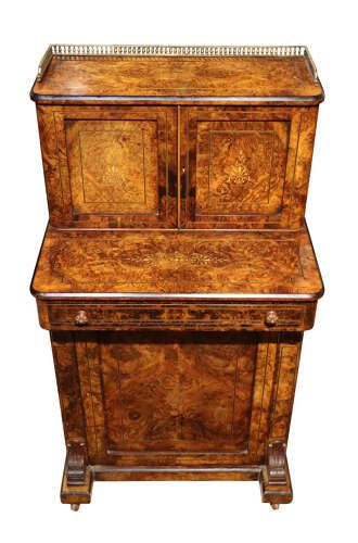 fig 2. A Victorian burr walnut bureau de dame featuring intricate brass inlay, a top cabinet with twin doors, a full-width drawer, and a lower cupboard set on castors.