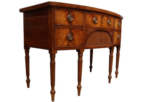 fig 1. A Regency mahogany bow-fronted sideboard featuring a central drawer with tambour cupboard below, flanked by drawers and supported on six turned, fluted legs.