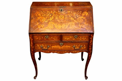 fig 2. An 18th-century Dutch bureau featuring intricate floral wood marquetry, a sloped fall front, drawers with brass handles, and cabriole legs.