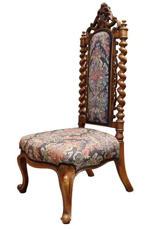 fig 1. A Victorian carved walnut side chair featuring barley twist columns, a carved scroll cresting rail, cabriole front legs, and floral tapestry upholstery.