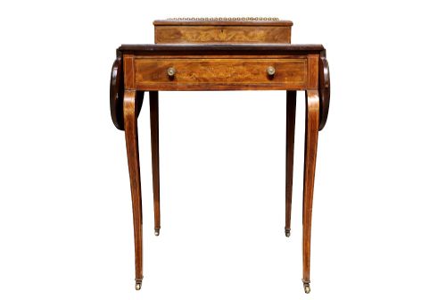 fig 2. An Edwardian rosewood writing table featuring a green leather writing surface, satinwood floral marquetry inlay, drop-leaf side panels, and a superstructure with brass gallery railing.