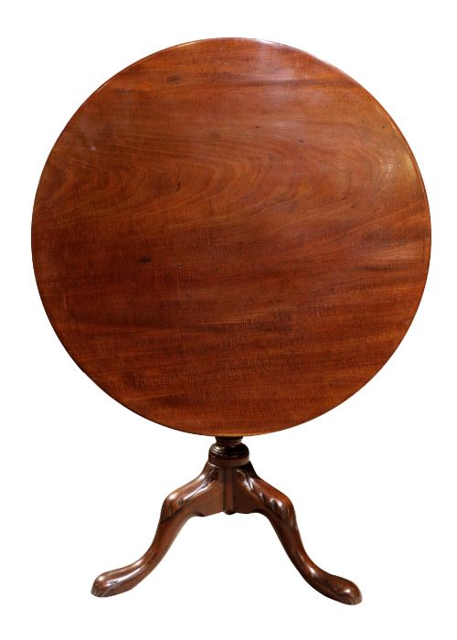 fig 1. A George IV circular mahogany tilt-top table featuring a turned central column with carved detailing and a tripod base resting on pad feet.