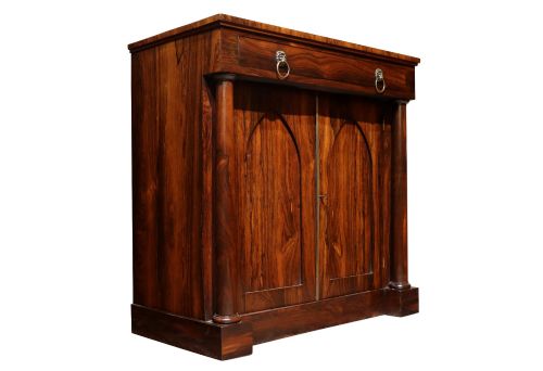 fig 1. A Regency period rosewood chiffonier featuring two Gothic arched panel doors flanked by turned columns and topped with a single drawer with twin brass lion-head ring handles.