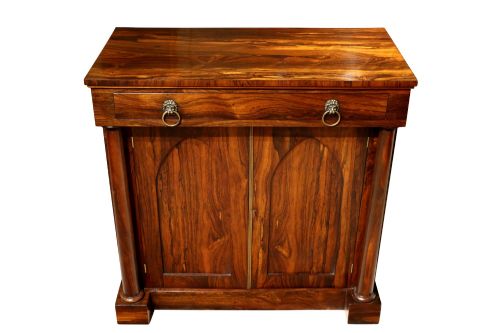 fig 2. A Regency period rosewood chiffonier featuring two Gothic arched panel doors flanked by turned columns and topped with a single drawer with twin brass lion-head ring handles.