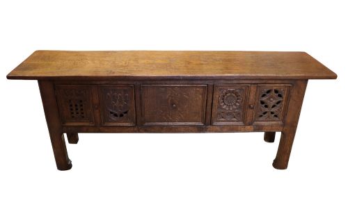 fig 1. A late 19th-century dark oak Gothic Revival dresser base featuring relief-carved panel doors with geometric tracery and floral motifs.