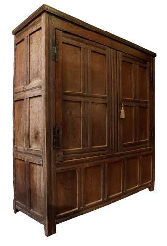 fig 1. A seventeenth-century dark oak vestment cupboard featuring twin panelled doors with iron hinges above a lower panelled base.