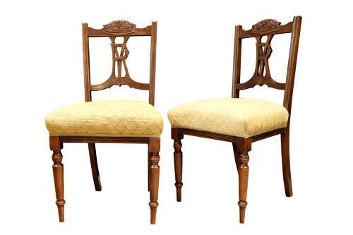 fig 1. A pair of Victorian carved walnut side chairs with openwork backrests displaying a carved royal crown and monogram, resting on turned front legs with upholstered seats.