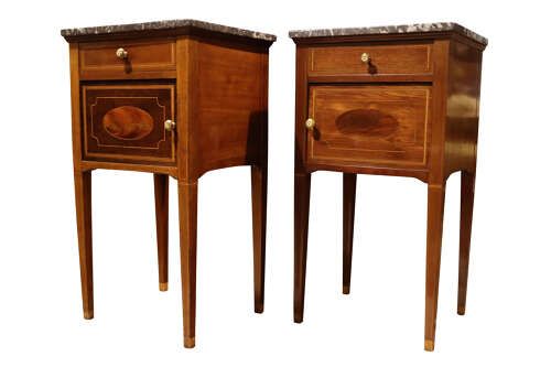 fig 1. Pair of tall, slender mahogany bedside cupboards with satinwood oval inlay, dark marble tops, single drawers, and square tapered legs.