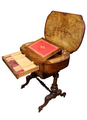 fig 2. A Victorian burr walnut sewing table featuring intricate marquetry inlay on top, turned legs with carved feet, and a drop-down sewing well beneath a single drawer.