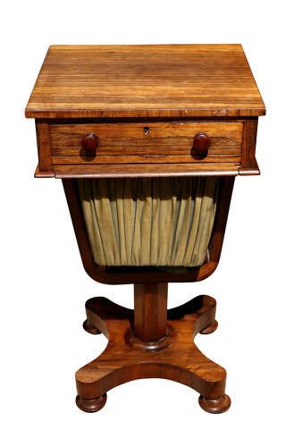 fig 1. A William IV rosewood pedestal sewing table featuring a single top drawer, a pleated fabric work well suspended from a U-shaped frame, and a quadform base.
