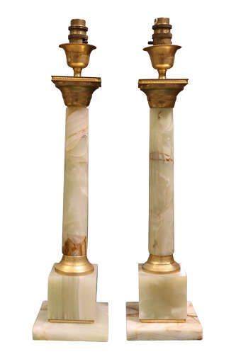 fig 1. A pair of Neoclassical style table lamps featuring pale green onyx columns mounted with gilt metal capitals and bases, topped with square white lampshades.