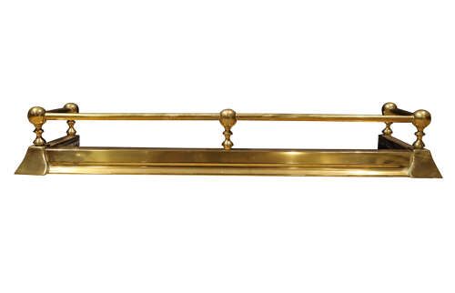 fig 1. An early twentieth-century brass fireplace fender featuring a raised top rail supported by five spherical ball finials over a moulded rectangular base.