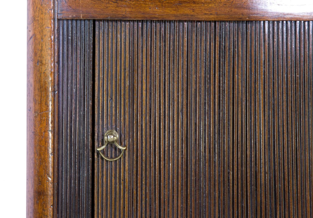 A George III mahogany tambour night stand featuring a cutout gallery top, a slatted sliding door, a single lower drawer with brass handles, and square legs. View VII